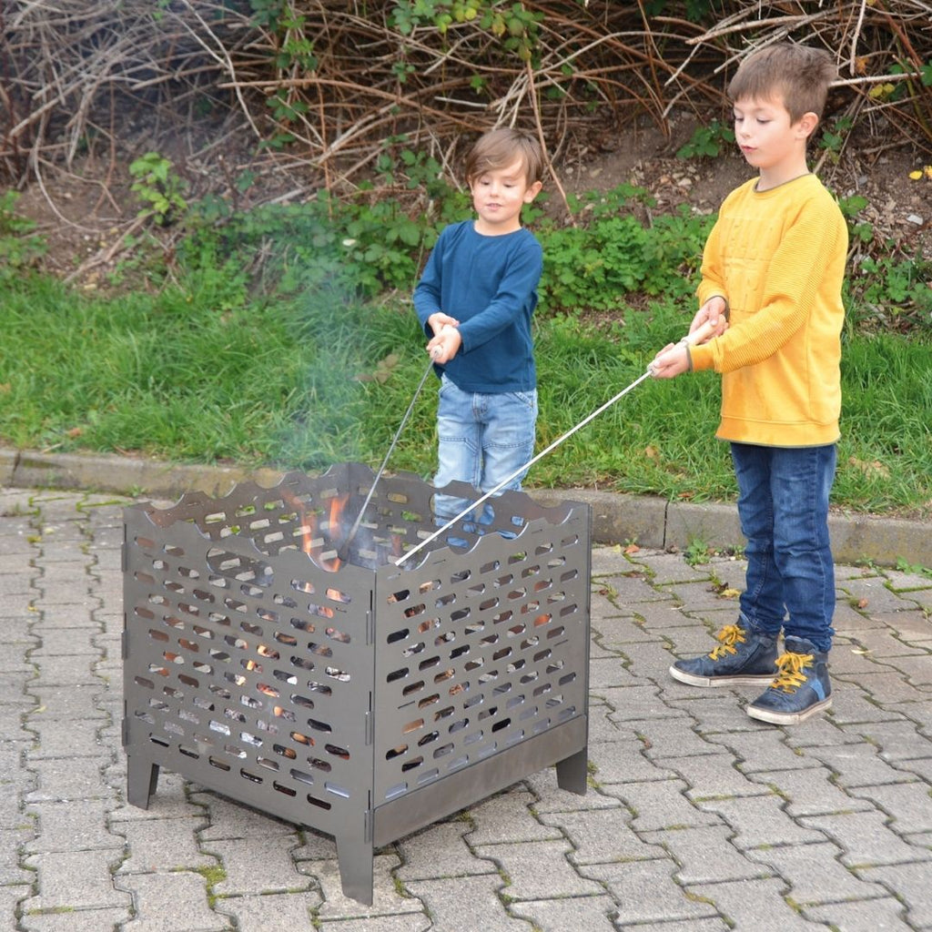 Lange afstand spiesen voor het bakken op een kampvuur vuurkorf buiten haard of bbq met kinderen brood bakken