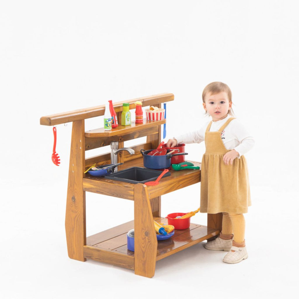 Peuters spelen met een houten buitenspeelkeuken met waterkraan, spoelbak en kookplaten. Ideaal buitenspeelgoed voor kinderdagverblijf of tuin, ontworpen voor kinderen onder de 3 jaar.